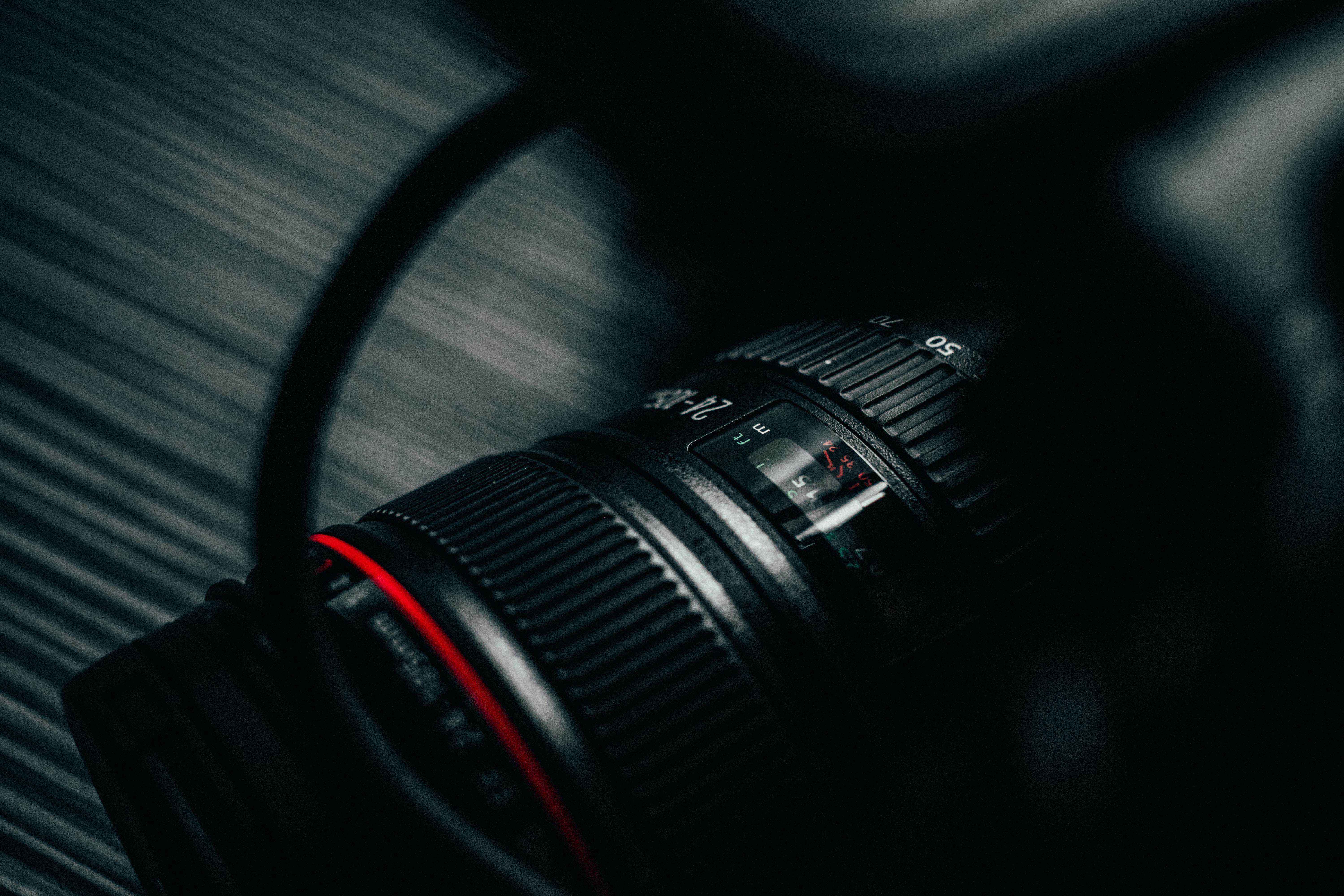 Detailed close-up view of a DSLR camera lens with subtle highlights, showcasing precision design.